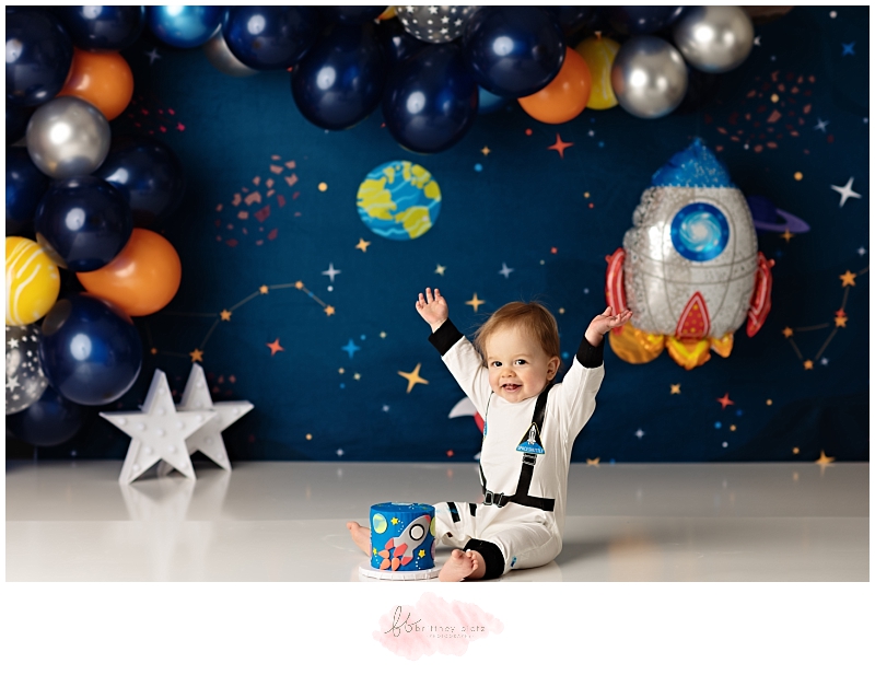 Calgary space themed cake smash astronaut boy hands in air